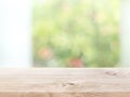 Empty wood table top on blur abstract green garden from window view in the morning Royalty Free Stock Photo