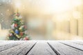 Empty wood table top on blur with bokeh Christmas tree and new`s year decoration on window banner background with snowfall - can Royalty Free Stock Photo