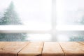 Empty wood table top on blur window view with pine tree in snow Royalty Free Stock Photo