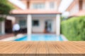 Empty wood table top on blurred background at swimming pool garden