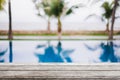 Empty wood table top and blurred swimming pool in tropical resort in summer banner background - can used for display or montage Royalty Free Stock Photo
