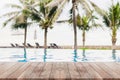 Empty wood table top and blurred swimming pool in tropical resort in summer banner background - can used for display or montage Royalty Free Stock Photo