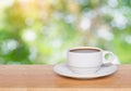 Empty wood table top and coffee cup blur nature background with copy space for display or montage your products Royalty Free Stock Photo