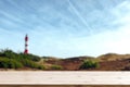 Empty wooden bar on bottom and blurred view of seaside landscape with red-white striped lighthouse Royalty Free Stock Photo