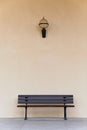 Empty wooden bench chair against blank wall, with light