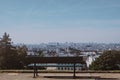 Empty wooden bench chair in garden in summer season with big city in France