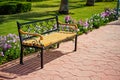 Empty wooden bench near green grass, beautiful flowers in park Royalty Free Stock Photo