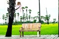 Empty wooden bench with Palm trees and Fresh Green Rice Field Nature on background Royalty Free Stock Photo