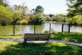 Empty wooden bench on pathway access lake side in Pessac gironde Royalty Free Stock Photo