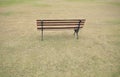 Empty wooden bench in a quiet public park with green lawn. rear view Royalty Free Stock Photo