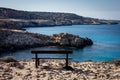 Empty wooden bench with a view to the sea at Blue Lagoon, Cape Greco, Cyprus. Royalty Free Stock Photo