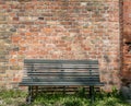 Empty wooden bench with vintage brick wall background, outdoors Royalty Free Stock Photo