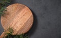 Empty wooden board on dark texture background with fir tree branch. Cutting board for serving food or preparing homemade and Royalty Free Stock Photo