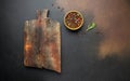 Empty wooden board with herbs and spices on black kitchen table. culinary background, top view Royalty Free Stock Photo