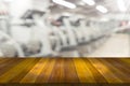 Empty wooden board space platform with blur fitness gym equipment background