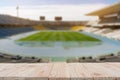 Empty wooden board table top on of blurred football soccer field background. with copy space for display or montage your Royalty Free Stock Photo