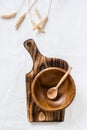 Empty wooden bowl and spoon on cutting board and ears on cloth. Top and vertical view Royalty Free Stock Photo