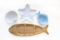 Empty wooden and ceramic plates in shape of fish, starfish and sea shell isolated on white background. Flat lay, top view Royalty Free Stock Photo