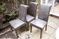 Empty wooden chairs in the garden. Old and used leathered chairs in the garden. Four dirty chairs. Home renovations and improvemen