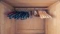 Empty wooden clothes closet with assortment of different coat hangers Royalty Free Stock Photo