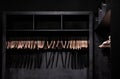 Empty wooden clothes hangers in empty black cloakroom, casting deep shadows. Royalty Free Stock Photo