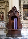 Empty confession box with purple curtain in a Catholic church in Italy. Royalty Free Stock Photo