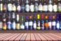 Wooden table with blurred background of many liquor and brandy on shelf of wooden wall decoration in vintage liquor store