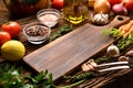 Empty wooden cutting board with copy space surrounded by peppers, herbs, tomatoes, mushrooms and other delicious flavoured vegetab