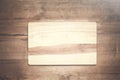 Empty wooden cutting board on a wood background.