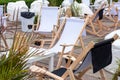 Empty wooden deck chairs near the cafe in summer. Tables and deckchairs at sidewalk cafe. Touristic setting, cafe table, sidewalk Royalty Free Stock Photo