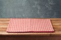 Empty wooden deck table with checked tablecloth over blackboard background for product montage Royalty Free Stock Photo