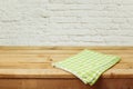 Empty wooden deck table with checked tablecloth over brick wall background Royalty Free Stock Photo