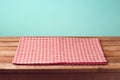 Empty wooden deck table with checked tablecloth over mint background for product montage Royalty Free Stock Photo