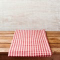 Empty wooden deck table with checked tablecloth over rustic wall. Royalty Free Stock Photo