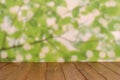 Empty wooden deck table with foliage bokeh background Royalty Free Stock Photo