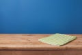 Empty wooden deck table with green checked tablecloth over blue wall background Royalty Free Stock Photo