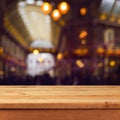 Empty wooden deck table over blurred bokeh shopping mall abstract background Royalty Free Stock Photo