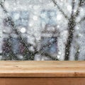 Empty wooden deck table over wet glass window. Rainy weather concept.
