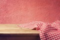 Empty wooden deck table with red checked tablecloth over red wall Royalty Free Stock Photo