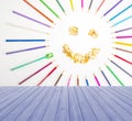 Empty wooden deck table with smiling sun arranged from crayons and pencil sharpening on blue background. Ready for product displ Royalty Free Stock Photo