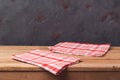 Empty wooden deck table with tablecloth over black wall background Royalty Free Stock Photo