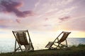 Empty wooden deckchairs on hill