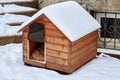 An empty wooden dog house in the winter on the back yard, covered with snow. Royalty Free Stock Photo