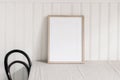 Empty wooden frame mockup on beige linen tablecloth background. White beadboard wainscot wall paneling background