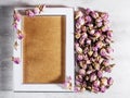 Empty wooden frame on the table near dry rose buds Royalty Free Stock Photo