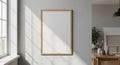 Empty wooden framed poster on a light grey wall with sunlight casting shadows from a window and supplies on a table Royalty Free Stock Photo