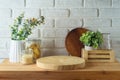 Empty wooden log on kitchen table with food jars and plants over white brick wall background. Kitchen mock up for design and Royalty Free Stock Photo