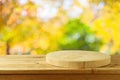 Empty wooden log on rustic table over blurred autumn leaves background.  Thanksgiving or Halloween holiday  mock up for design and Royalty Free Stock Photo