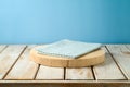 Empty wooden log with tablecloth on rustic table over blue wall  background.  Kitchen mock up for design and product display Royalty Free Stock Photo