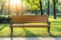 Empty wooden park bench at sunset surrounded by vibrant trees and warm sunlight creating a nostalgic atmosphere Royalty Free Stock Photo